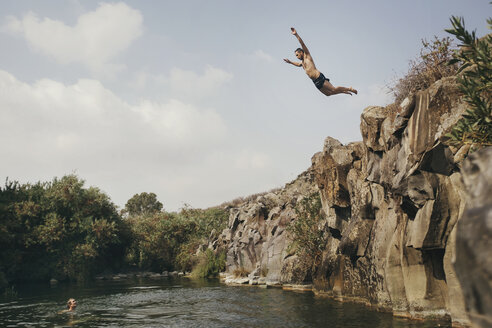 Junger Mann springt von einer Klippe, Yehudiya Reserve, Golan, Israel - GCF00253
