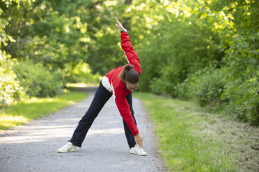 Weibliche reife Joggerin im Wald, sich streckend - FLLF00211