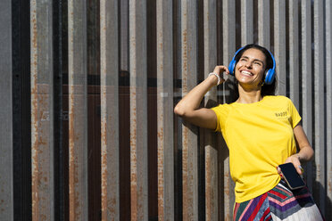 Frau mit blauen Kopfhörern hört Musik - ERRF01362