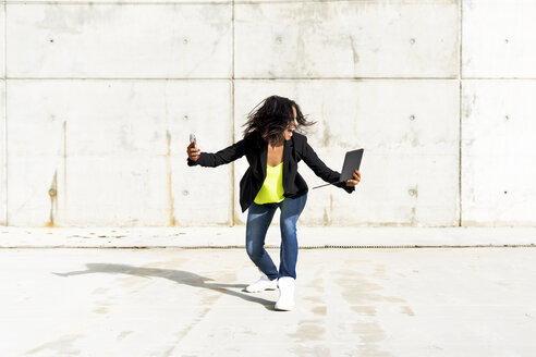 Woman holding smartphone and tablet, screaming and taking a selfie - ERRF01373