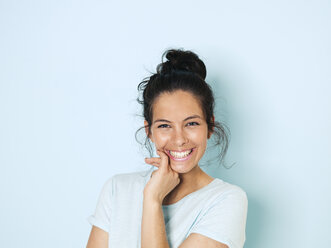 Portrait of young woman with black hair, light blue background - HMEF00391