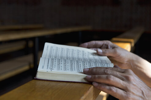 Hände auf dem Gesangbuch auf der Kirchenbank - ASF06430