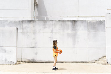 Teenager-Mädchen mit Basketball stehend im Freien - ERRF01390