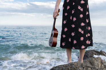 Frau mit Ukulele vor dem Meer stehend, Teilansicht - AFVF02972