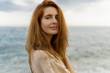 Portrait of redheaded young woman with nose piercing standing in front of the sea - AFVF02985