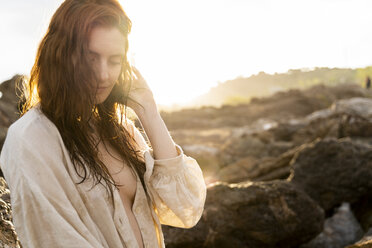 Porträt einer rothaarigen jungen Frau bei Sonnenuntergang - AFVF02999