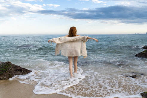 Rückenansicht einer rothaarigen jungen Frau an der Strandpromenade - AFVF03001