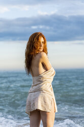 Porträt einer rothaarigen jungen Frau, die vor dem Meer steht - AFVF03005
