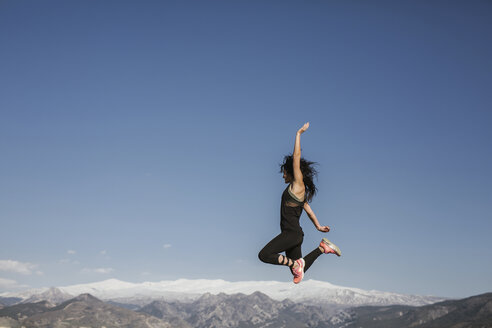 Springende Frau vor dem Hintergrund der Sierra Nevada, Andalusien, Spanien - LJF00012