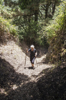 Ältere Frau beim Wandern durch den Wald im Garajonay-Nationalpark, La Gomera, Kanarische Inseln, Spanien - MAMF00677