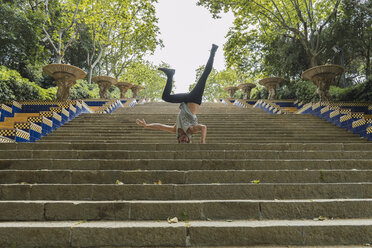 Junger Mann macht Akrobatik auf einer Treppe im Freien - AFVF03017
