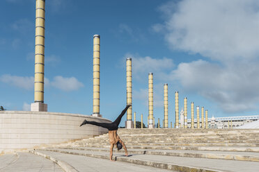 Young man doing acrobatics on stairs outdoors - AFVF03023