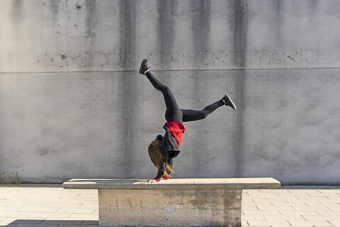 Teenager-Mädchen macht einen Handstand im Freien, lizenzfreies Stockfoto