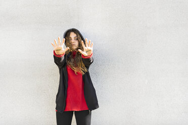 Portrait of serious teenage girl showing the words fight and sexism written on her palms - ERRF01398