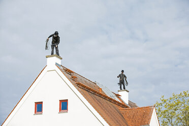 Zwei Schornsteinfeger arbeiten auf dem Dach eines Hauses - MAEF12896