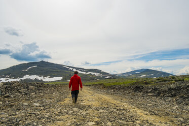 Man walking on mountain path in winter - BLEF04425