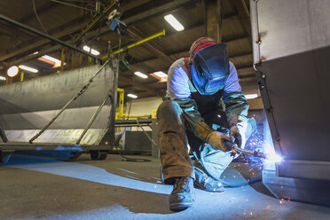 Caucasian man welding metal in factory - BLEF04459