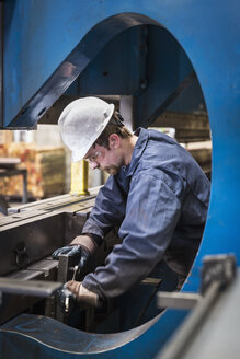 Kaukasischer Arbeiter, der in einer Fabrik Metall verarbeitet - BLEF04482