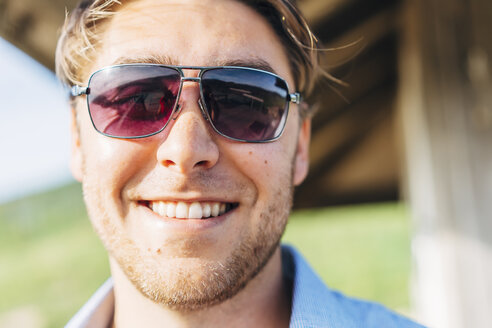Lächelnder kaukasischer Mann mit Sonnenbrille - BLEF04572