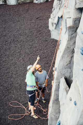 Frau und Mann schauen auf eine Kletterwand, lizenzfreies Stockfoto