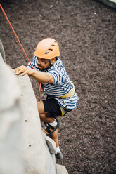 Mixed Race Mann klettert an der Kletterwand - BLEF04595