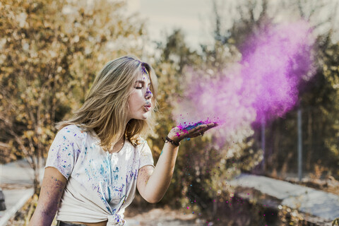 Girl blowing Holi powder colours, Germany stock photo