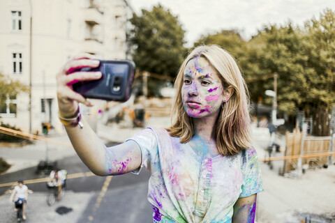 Gir Holi Pulver Farben im Gesicht, Selfie machen, Deutschland, lizenzfreies Stockfoto