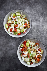 Two bowls of salad with cucumbers, chickpeas, onion, cherry tomatoes, basil, chia seed - GIOF06356