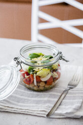 Glass of salad with cucumbers, chickpeas, onion, cherry tomatoes, basil, chia seed and sliced almonds - GIOF06363