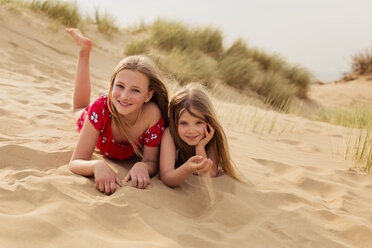 Portrait of two smiling girls lying on the beach - NMS00310