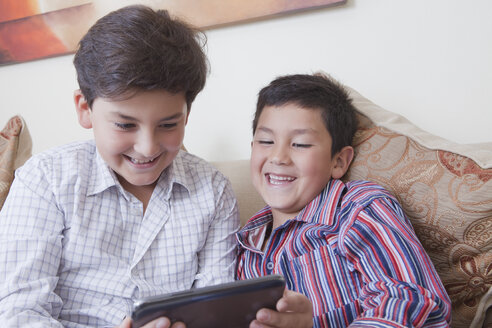 Hispanic brothers using digital tablet - BLEF04638