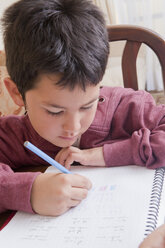 Hispanic boy doing homework at table - BLEF04652