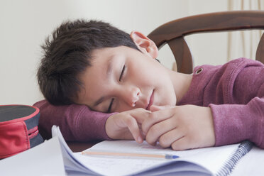 Hispanischer Junge schläft bei den Hausaufgaben am Tisch - BLEF04653