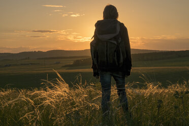 Kaukasische Frau bewundert Landschaft bei Sonnenuntergang - BLEF04664