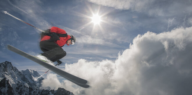Kaukasischer Skifahrer, der auf einem Berg in die Luft springt - BLEF04666