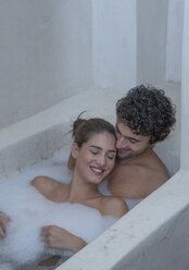 Smiling Caucasian couple relaxing in bathtub - BLEF04677