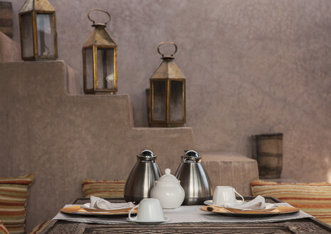 Kaffeekannen und Teller am Tisch neben der Treppe - BLEF04680