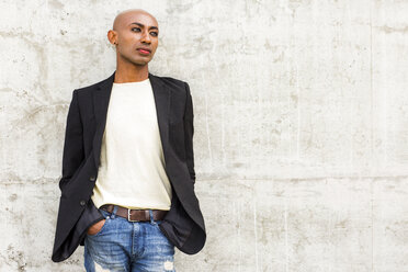 Pensive gay Black man leaning on concrete wall - BLEF04706