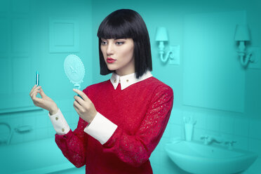 Caucasian woman in teal old-fashioned bathroom applying lipstick - BLEF04758