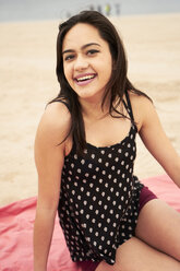 Mixed Race woman sitting on blanket at beach - BLEF04796