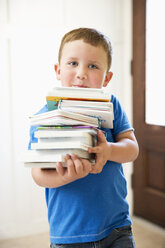 Kaukasischer Junge trägt einen Stapel Bücher - BLEF04822