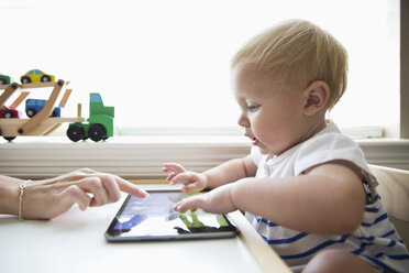 Caucasian mother helping baby girl use digital tablet - BLEF04827