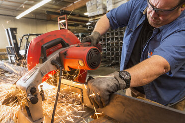 Kaukasischer Arbeiter schneidet Metall in einer Fabrik - BLEF04835