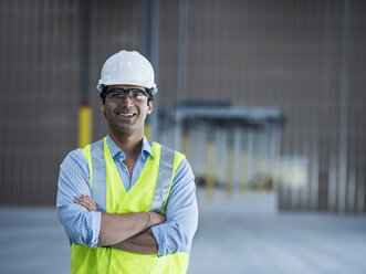 Smiling Indian worker in empty warehouse - BLEF04856