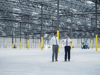 Businessmen talking in empty warehouse - BLEF04868