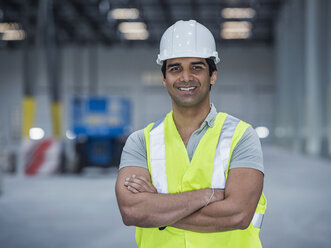 Lächelnder indischer Arbeiter im Lagerhaus - BLEF04880