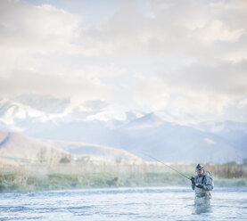 Caucasian man fly fishing in river - BLEF04968