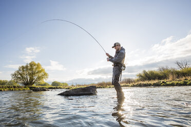 Fly fisherman throwing fishing reel in river to catch fish during sunset  Stock Photo - Alamy