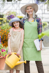 Caucasian grandmother and granddaughter posing in greenhouse - BLEF05003