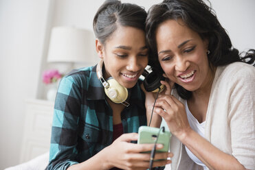 Mutter und Tochter hören über Kopfhörer Musik aus dem Handy - BLEF05036